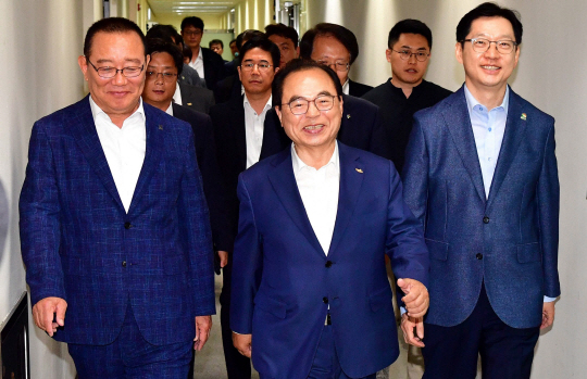 지난해 6월 20일 송철호(앞줄 왼쪽부터) 울산시장, 오거돈 부산시장, 김경수 경남지사가 서울 LS 용산타워에서 동남권 신공항 문제 해결을 위해 김현미 국토교통부 장관을 만나러 밝은 표정으로 걸어가고 있다.   뉴시스