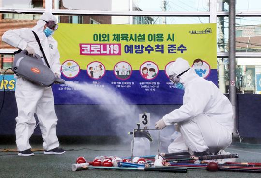 23일 서울 송파구 아우름체육센터 내 게이트볼장에서 국민안전교육연수원과 송파구청 방역 관계자들이 정부의 사회적 거리두기 완화 방침에 따라 임시 휴장했던 시설의 재개장을 앞두고 방역작업을 하고 있다.   연합뉴스