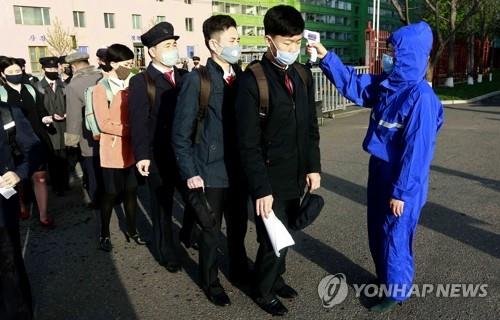(평양 AP=연합뉴스) 신종 코로나바이러스 감염증(코로나19) 사태로 방학 연장 조치를 취했던 북한 평양의 김책공업종합대학이 22일 개학한 가운데 재학생들이 마스크 차림으로 등교하며 체온 검사를 받고 있다. 2020.4.26