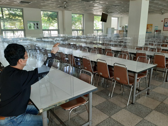 조만간 있을 오프라인 개학을 앞두고 대구 북구 칠성고 행정공무원이 신종 코로나바이러스 감염증(코로나19) 확산을 막기 위해 급식실 식탁 자리마다 설치한 투명 칸막이를 점검하고 있다.