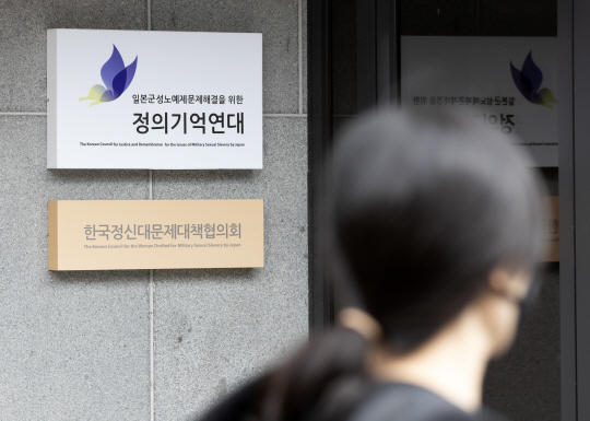 20대 여성이 ‘정의기억연대(정의연)’ 서울 마포구 성산동 사무실 간판을 지난 12일 지나가면서 쳐다보고 있다. 연합뉴스