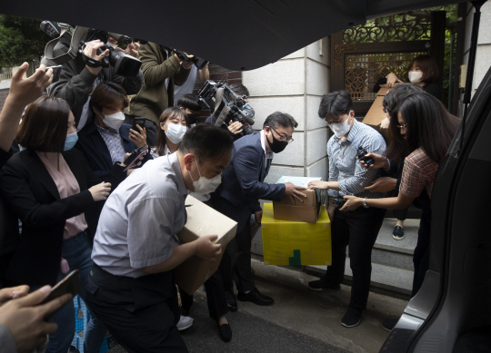 검찰이 21일 오후 서울 마포구 정의기억연대 쉼터에서 압수수색을 통해 확보한 압수품들을 차로 옮겨 싣고 있다. 연합뉴스
