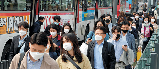 마스크 미착용 시 대중교통 탑승 제한 조치가 시작된 26일 오전 서울 광화문 사거리 버스정류장에 내린 출근길 시민들이 마스크를 착용하고 일터로 향하고 있다.  김낙중 기자