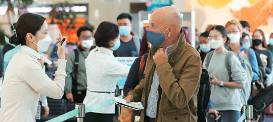 비행기 탑승객의 마스크 의무 착용이 시행된 27일 인천국제공항에서 마스크를 쓴 승객들이 탑승 수속을 밟고 있다.  연합뉴스