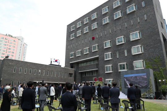 10일 오전 제33주년 6·10민주항쟁 기념식이 열린 서울 용산구 남영동 민주인권기념관(옛 남영동 대공분실) 옥상에 행사 진행요원이 대형 태극기를 들고 서 있다.  뉴시스