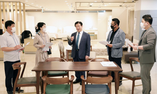 김경수(가운데) 에몬스가구 회장이 ‘2020 F/W 신제품 품평회’에서 대리점주들에게 식탁 등 새롭게 선보일 가구에 대해 설명하고 있다.
