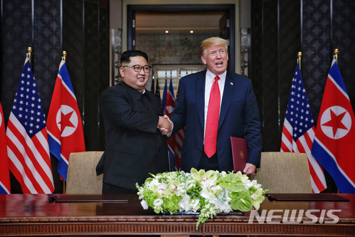 【서울=뉴시스】 2018년 6월12일 김정은 북한 국무위원장과 도널드 트럼프 미국 대통령이 싱가포르 센토사섬 카펠라 호텔에서 북미정상회담 합의문 서명하고 악수를 하고 있다. 2020.06.22.(사진=싱가포르 통신정보부 제공)