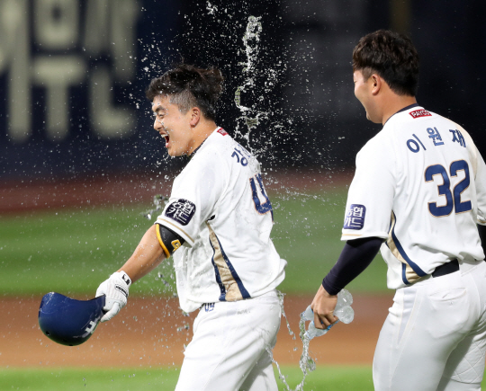 NC 강진성이 지난달 13일 경남 창원NC파크에서 열린 KT와의 홈경기에서 연장 10회 말 끝내기 안타를 날린 뒤 동료들로부터 물세례를 받으며 활짝 웃고 있다.  연합뉴스