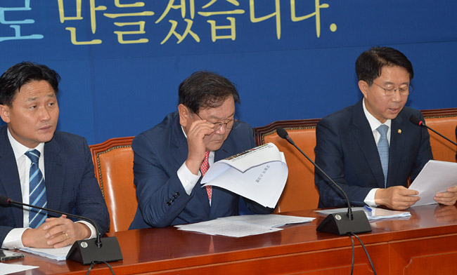 김태년(가운데) 더불어민주당 원내대표가 2일 오전 국회에서 열린 정책조정회의에서 조간신문 스크랩을 보고 있다. 왼쪽부터 김영진 원내수석부대표, 김 원내대표, 조정식 정책위의장. 김낙중 기자