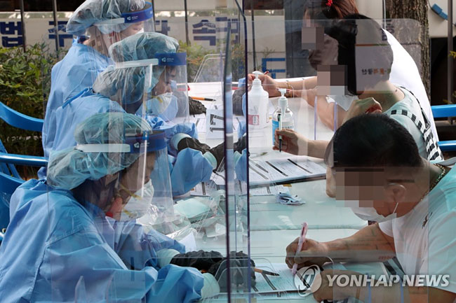 7월 7일 오후 광주 광산구 신창동 행정복지센터에 마련된 코로나19 간이 선별진료소에서 시민이 진단검사 서류를 작성하고 있다. [연합뉴스 자료사진]