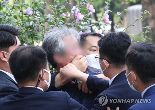 (서울=연합뉴스)  대통령 경호원들이 16일 오후 서울 여의도 국회에서 열린 제21대 국회 개원식에 참석한 문재인 대통령을 향해 신발을 던지고 소리를 지르는 시민의 입을 막고 있다.2020.7.16