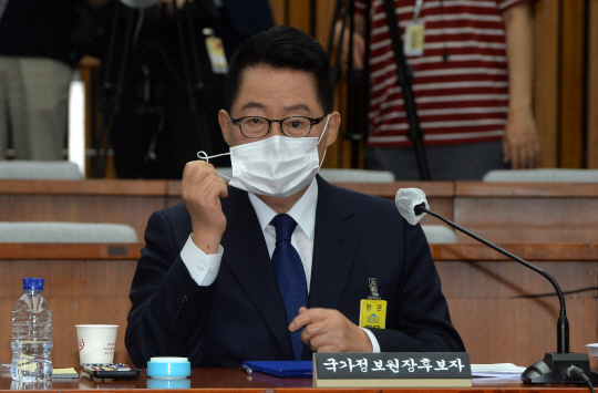 박지원 국가정보원장 후보자가 27일 국회에서 열린 인사청문회에서 후보자 선서를 하기 위해 마스크를 벗고 있다. 김낙중 기자