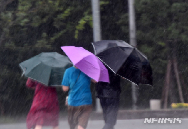 [부산=뉴시스] 제5호 태풍 ‘장미’가 북상함에 따라 부산지역에 태풍주의보가 발효된 10일 오후 해운대해수욕장을 찾은 시민들이 비바람에 맞서 힙겹게 걸어가고 있다. 2020.08.10.