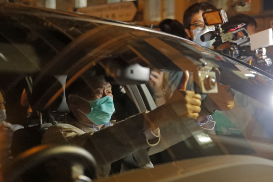 홍콩의 반중 매체 핑궈르바오 사주 지미 라이가 체포된 지 하루 만인 11일 보석으로 풀려난 뒤 승용차 안에서 눈에 눈물이 맺힌 상태에서 비장한 표정으로 취재진에게 양손 엄지를 치켜들어 보이고 있다. AP 연합뉴스