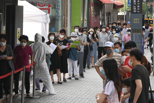 코로나19 집단감염이 발생한 사랑제일교회 소재지인 서울 성북구에서 18일 오전 주민들이 하월곡동 성북구 보건소를 찾아 길게 줄을 서 진단검사 차례를 기다리고 있다.