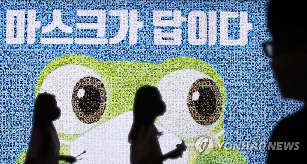 (수원=연합뉴스) 홍기원 기자 = 18일 오후 경기도 수원역에 설치된 마스크를 착용한 시민들의 사진을 모아 만든 ‘마스크가 답이다’ 광고판 앞을 시민들이 지나고 있다.경기도는 18일 신종 코로나바이러스 감염증(코로나19) 재확산과 관련, 도내 전 지역 거주자와 방문자를 대상으로 마스크 착용을 의무화하는 행정명령을 발동했다. 2020.8.18