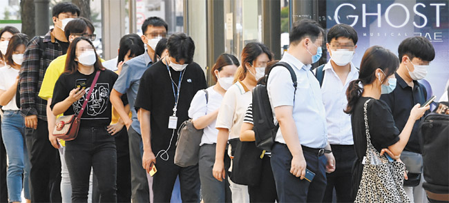 서울시의 마스크 착용 의무화가 시행된 24일 오전 서울 마포구 합정역 사거리에서 출근길 시민들이 마스크를 쓴 채 버스를 기다리고 있다. 하지만 줄을 서며 앞사람과 2m(최소 1m) 이상 거리를 둬야 하는 방역수칙은 지켜지지 않고 있다.  김낙중 기자