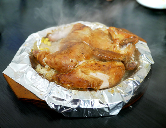경기 일산 ‘누룽지 품은 닭’의 대표 메뉴. 장작불에 구운 닭을 누룽지 위에다 올려서 먹는다.