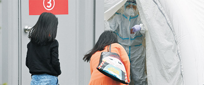 3일 오전 서울 종로구 교남동 서울적십자병원을 찾은 여성이 코로나19 검사를 위해 선별 진료소로 들어가고 있다. 김동훈 기자