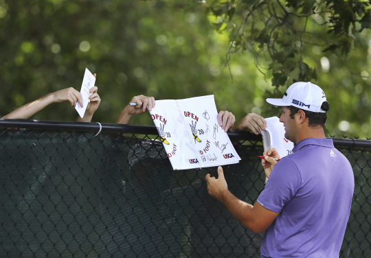 PGA투어 플레이오프 2차전 BMW챔피언십 우승자인 스페인의 욘 람이 4일 오전(한국시간) 미국 조지아주 애틀랜타 이스트 레이크 골프클럽에서 투어챔피언십 연습 라운드 도중 팬들에게 사인을 해주고 있다.  AP 연합뉴스