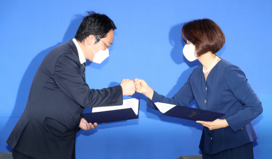 최대집(왼쪽) 대한의사협회장과 한정애 더불어민주당 정책위의장이 4일 오전 서울 여의도 민주당사에서 “의대 정원 확대, 공공의대 신설 추진 등을 원점에서 재검토한다”는 내용이 담긴 의료계 파업 철회 합의안에 서명한 뒤 주먹 인사를 나누고 있다.  김낙중 기자
