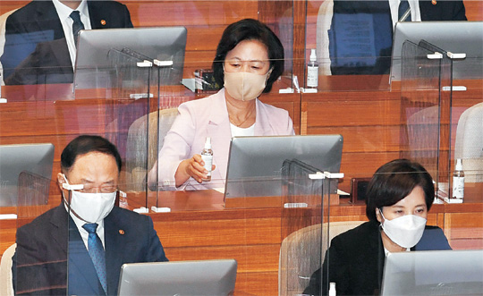 추미애(두 번째 줄) 법무부 장관이 7일 오전 국회 본회의장에서 이낙연 더불어민주당 대표의 교섭단체연설을 듣기에 앞서 책상에 놓인 손 세정제를 살펴보고 있다.