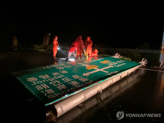 (제주=연합뉴스) 7일 오전 태풍 하이선의 영향으로 제주시 구좌읍 한 도로에 있는 도로 표지판이 떨어져 소방관들이 안전 조치를 하고 있다. 2020.9.7 [제주도 소방안전본부 제공. 재판매 및 DB 금지]