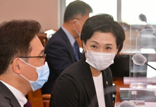 김현미(오른쪽) 국토교통부 장관이 11일 국회에서 열린 국토교통위원회 전체회의에 출석해 마스크를 쓴 채 박선호 국토부 차관과 이야기를 나누고 있다.   국회사진기자단