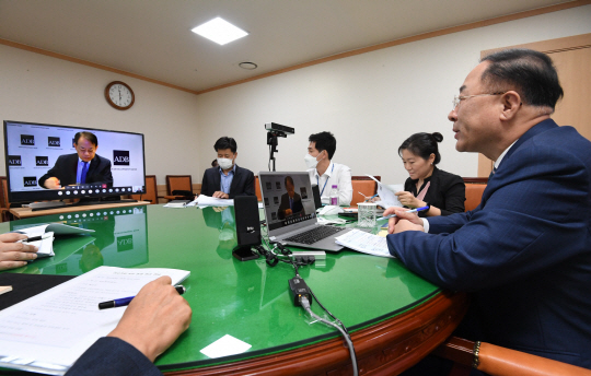 2019·2020년도 아시아개발은행(ADB) 총회 의장인 홍남기(오른쪽) 부총리 겸 기획재정부 장관이 14일 정부서울청사에서 모니터를 통해 아사카와 마사쓰구 ADB 총재와 화상으로 면담하고 있다.  기획재정부 제공