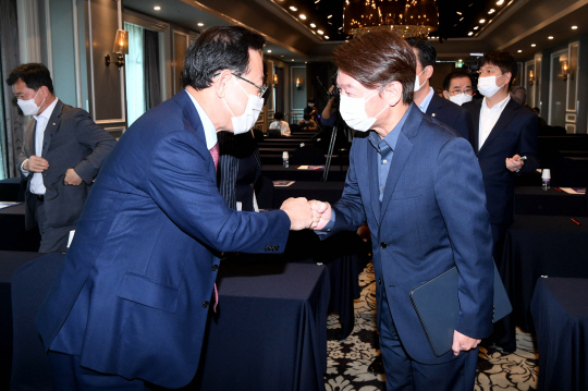 안철수(오른쪽) 국민의당 대표와 주호영(왼쪽) 국민의힘 원내대표가 23일 오전 서울 여의도 켄싱턴호텔에서 열린 ‘대한민국 미래혁신포럼’에서 만나 주먹 인사를 하고 있다. 국회사진기자단