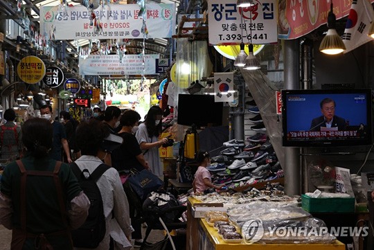 (서울=연합뉴스) 추석 연휴를 일주일여 앞둔 22일 장을 보러 나온 시민들로 북적이는 서대문구 영천시장에 문재인 대통령의 추경 관련 국무회의 발언 모습이 방송되고 있다. 2020.9.22