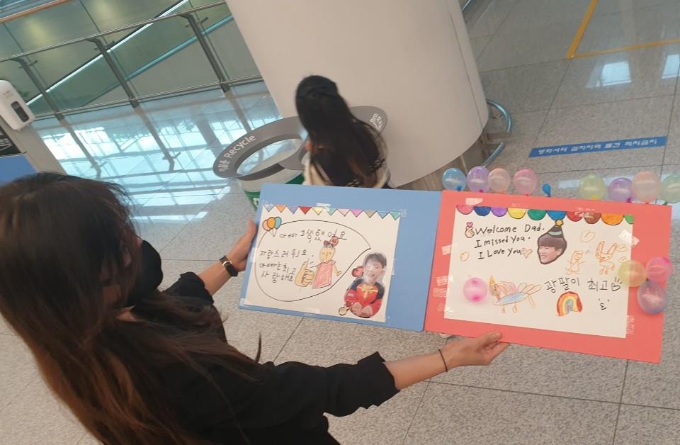 김광현의 아내 이상희 씨가 7일 인천국제공항 입국장에서 자녀들이 만든 환영 플래카드를 보여주고 있다.