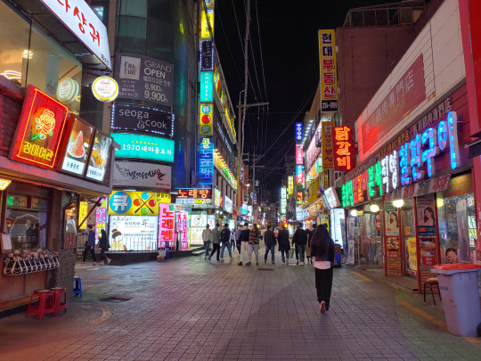 사회적 거리두기가 1단계로 완화된 첫날인 12일 저녁 서울 서대문구 신촌 인근 대학가에서 화려한 네온사인 사이로 사람들이 걸어가고 있다.  김온유 기자