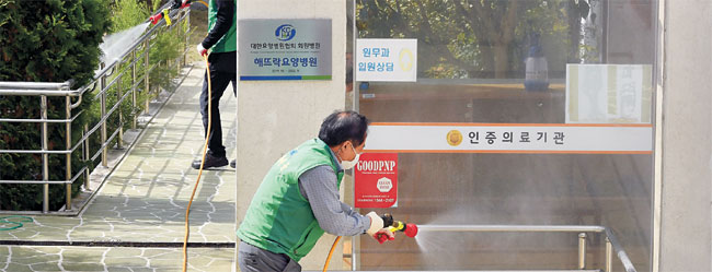 부산 북구의 해뜨락요양병원에서 직원과 환자 등 53명이 신종 코로나바이러스 감염증(코로나19) 확진을 받은 가운데 14일 오전 병원 건물 주변에서 구청 관계자들이 방역 소독을 하고 있다. 뉴시스