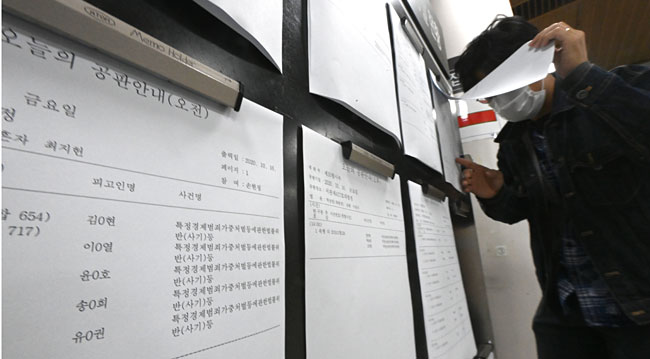 5000억 원대 피해를 유발한 옵티머스자산운용 핵심 관계자의 첫 공판이 열린 16일 서울 서초구 서울중앙지법 공판 안내 게시판에 옵티머스 사건 관련 공판 안내문이 붙어 있다.  신창섭 기자