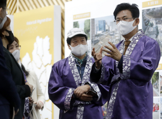 15일 서울 강남구 대치동 서울무역전시장(SETEC)에서 진행된 2020 대한민국 도시재생산업박람회에서 박성수(오른쪽) 송파구청장이 송파구 전시관을 찾은 관람객들에게 도시재생의 성과와 비전에 대해 설명하고 있다. 송파구청 제공