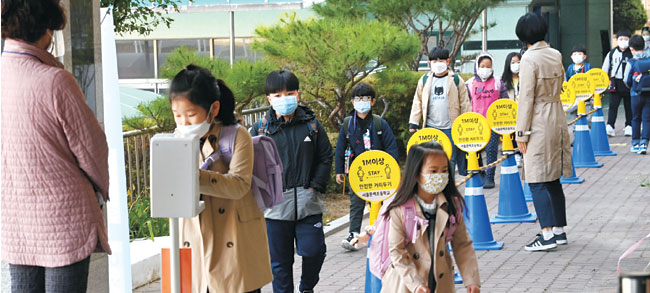 전국 유·초·중·고교의 등교 인원 밀집도 제한이 3분의 1에서 3분의 2로 완화된 19일 오전 서울 금천구 문백초에서 학생들이 거리를 유지한 채 등교하고 있다.