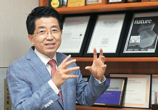 현택환 교수가 지난 13일 서울대 연구실에서 자신의 대표 논문 액자 진열장 앞에 서서 당시 연구 에피소드를 소개하고 있다.