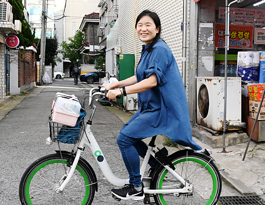 추혜인 ‘살림의원’ 원장이 지난 27일 오후 서울 은평구 구산동 길거리에서 왕진 가방을 실은 서울시 공공자전거 ‘따릉이’를 타고 환하게 웃고 있다.