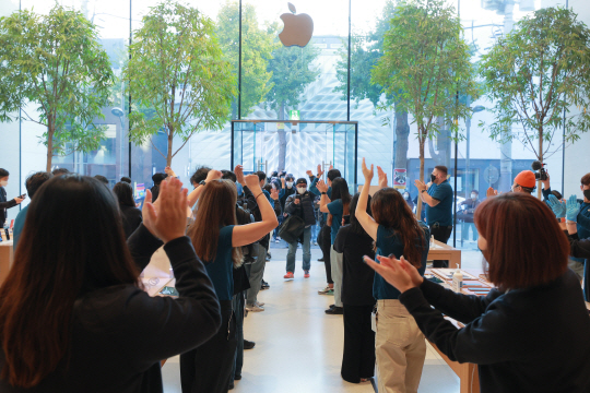 애플의 신제품 ‘아이폰12’가 정식 출시된 30일 오전 서울 강남구 신사동에 있는 애플 가로수길 매장을 찾은 시민들이 직원들의 환호를 받으며 입장하고 있다. 연합뉴스