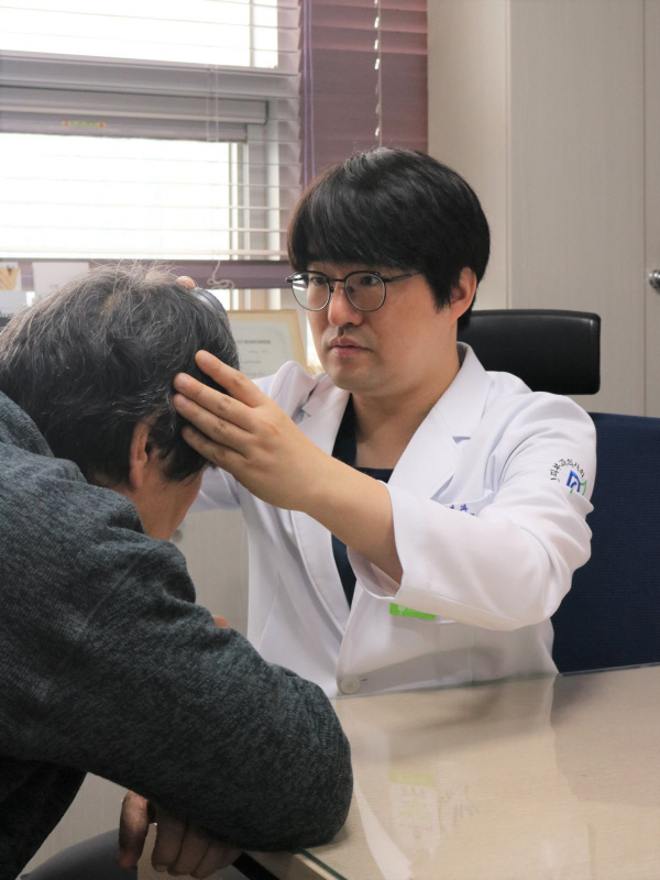 이영규 아름다운피부과의원 원장이 탈모 증세를 호소하는 남성 환자의 두피 상태를 점검하고 있다. 아름다운피부과의원 제공.