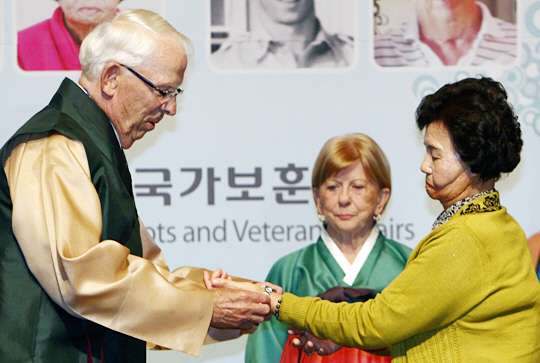 2013년 60년 만에 재회한 6·25전쟁 영웅 리처드 캐드월러더가 김연순 할머니에게 손목시계를 건네는 장면. 김 할머니는 1953년 12살 소녀 시절 캐드월러더 덕분에 화상 치료를 받아 재활에 성공했다.  국가보훈처 제공