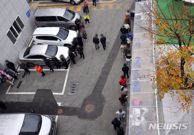 [부산=뉴시스] 부산지역에 신종 코로나바이러스 감염증(코로나19) 확진자가 급증하고 있는 가운데 26일 오전 부산진구보건소 선별진료소를 찾은 시민들이 코로나19 진단검사를 받기 위해 길게 줄을 선 채 차례를 기다리고 있다. 2020.11.26.