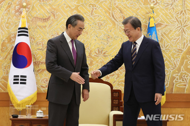 [서울=뉴시스]문재인 대통령이 26일 오후 청와대에서 왕이(王毅) 중국 외교담당 국무위원 겸 외교부장과 인사하고 있다. 코로나19 방역에 따른 의전 계획에 따라 계획에 없던 악수라 왕이 외교부장이 잠시 머뭇거리고 있다. 2020.11.26.