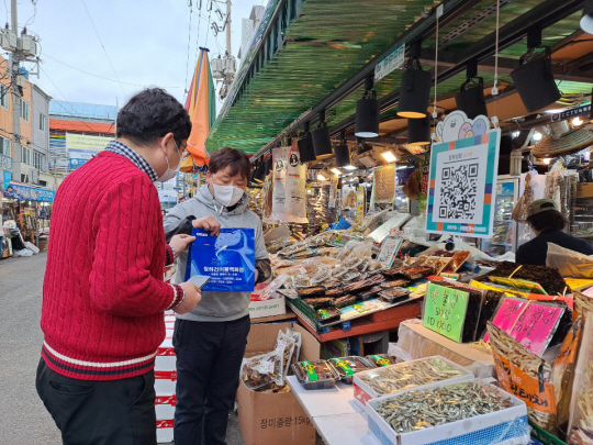 경북 포항시 죽도시장을 찾은 한 소비자가 26일 시장 내 건어물 상점에서 모바일 온누리상품권으로 제품을 구입하고 있다.
