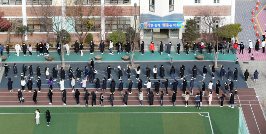 신종 코로나바이러스 감염증(코로나19) 확진자가 발생한 것으로 알려진 서울 중랑구 한 초등학교 학생들이 2일 학교 내 체육관에 차려진 임시 선별진료소에서 검사를 받기 위해 줄지어 대기하고 있다. 연합뉴스