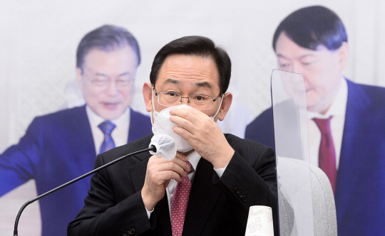 주호영 국민의힘 원내대표가 4일 오전 국회에서 열린 원내대책회의에서 발언을 마친 뒤 마스크를 고쳐 쓰고 있다. 주 원내대표의 뒤편엔 문재인 대통령과 윤석열 검찰총장의 사진이 걸려 있다. 국회사진기자단