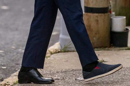 깁스를 푼 조 바이든 미국 대통령 당선인이 3일 운동화와 구두를 신고 인수위원회 사무실이 있는 델라웨어주 윌밍턴의 더 퀸시어터에 들어서고 있다.  AP 연합뉴스