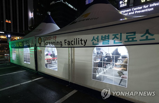 (서울=연합뉴스)  13일 오후 서울 강남구 보건소 선별진료소를 찾은 시민들이 신종 코로나바이러스 감염증(코로나19) 검체 채취를 위해 문진표를 작성하며 차례를 기다리고 있다. 2020.12.13