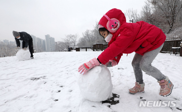 [서울=뉴시스] 지난 13일 서울 강북구 북서울꿈의숲공원을 찾은 한 어린이가 눈사람을 만들고 있다. 2020.12.13.